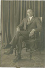 Portrait of an unidentified man sitting in a chair.