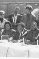 Southern Christian Leadership Conference President Joseph E. Lowery and others speak at an event outdoors at The King Center celebrating the release of Nelson Mandela from prison. Written on verso: Coretta Scott King, Joseph E. Lowery, ANC Representative and others from community gathered at Dr. King's crypt to celebrate the release of Mandela, but call for the sanctions to remain.
