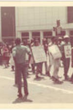 Marchers carrying protest signs walk through Atlanta during the Sanitation Worker's Strike. Written on accompanying document: The 36 day strike of city sanitation workers demonstration, downtown Atl.