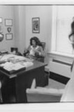 Vivian Malone Jones talks with a man and woman in her office.