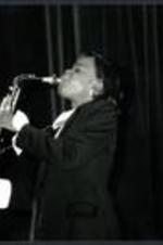An unidentified woman plays the saxophone.