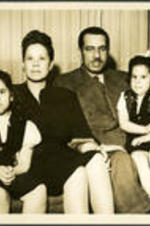 Brailsford R. Brazeal and family sit on a couch. Left to right: (daughter) Ernestine Walton Brazeal, (wife) Ernestine E. Brazeal, Brailsford R. Brazeal, and (daughter) Aurelia Erskine Brazeal.