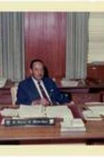Dr. Harry V. Richardson seated at his desk.