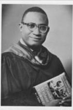 A portrait photo of Lawrence Reddick posing with his book, "Crusader Without Violence: A Biography of Martin Luther King, Jr.", the first biography written about Martin Luther King, Jr.