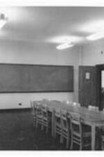 Interior of a classroom with a table and chairs in Dean Sage Hall.