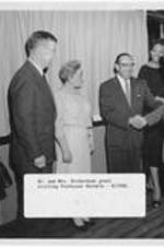 Dr. Harry V. Richardson shakes hands with Professor Dorokin. Written on recto: Dr. and Mrs. Richardson greet visiting Professor Dorokin  - 4/1958.