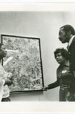 Margaret Burroughs stands in front of a painting with others. Written on verso: By Normal L. Hunter Jet Magazine.
