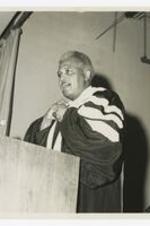 View of man at podium with graduation gown.