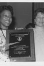 Evelyn  G. Lowery awards Laquisha Cunningham of Anniston, Alabama as the first place winner in the SCLC/WOMEN'S annual national oratorical contest. The topic of the contest dealt with the apartheid mentality in South Africa and the United States. Caption quoted from October/November 1986 SCLC Magazine, page 45. For further information, see https://radar.auctr.edu/islandora/object/auc.199%3A07031.