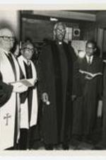 Indoor group portrait of 5 men wearing clerical robes.