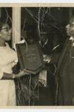 George A. Sewell receives a plaque from a woman.