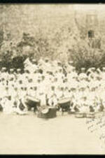 Alton Adams bandmaster, and his band with instruments in a field.