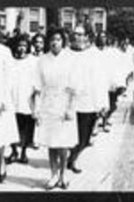 Women missionaries walk down a sidewalk.