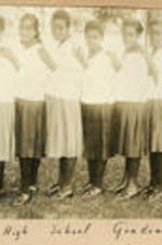 Eleven young women pose in a line. Written on recto: High School Graduates.