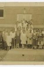 Outdoor group portrait of men and women in front of brick building. Written on verso: Mr. W. Hubert, 1) Commencement photo, 2) 31 Graduation Class; written on recto: Univ. Extension Group Athens GA 1929.