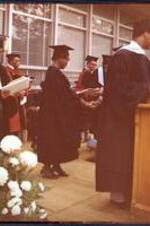 A woman receives her diploma at commencement.