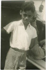 A young boy stands near other children. Written on verso: Boy, Kingston, St. Vincent; Photograph by Carl Van Vechten; 101 Central Park West; Cannot be reproduced without permission; March 4, 1951.