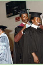 An unidentified graduate receives a hood.