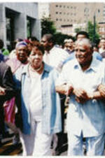 Reverend Al Sharpton, Evelyn G. Lowery, Joseph E. Lowery, and U.S. Representative John Lewis march arm in arm ahead of other demonstrators during a protest.