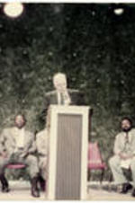 Dean Lawrence N. Jones, Howard Divinity School, speaks at the podium as Clark President Elias Blake, C. Eric Lincoln, Alex Haley, and an unidentified man look on.