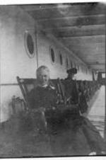 A woman seated on a chair on a ship. Written on verso: Miss Abbott.
