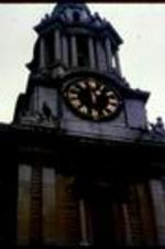 A clock tower surrounded by statues.