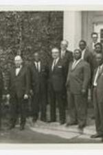 James P. Brawley and a group of men pose on the steps of a building.
