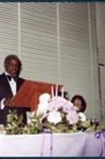 A man speaks from the podium at a banquet event.