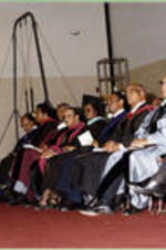 Platform participants (President, Board of Trustees, and Deans) listen to a commencement address during I.T.C. graduation ceremony.