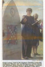 A scanned and printed image of a newspaper clipping featuring Evelyn G. Lowery speaking next to the Viola Liuzzo memorial monument, which is vandalized with the painting of a Confederate flag.