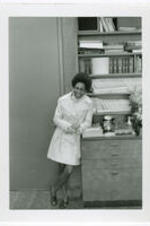 Carole Parks stands in an office and smiles.