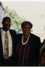 A group stands with their arms around each other at the I.T.C. Grand Reunion. Written on verso: Gloria Tate, Mr. Simmons, Minnie, Katie Cannon. ITC Grand Reunion 1994.