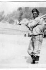 An unidentified baseball player holds a bat over his shoulder.