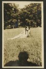 A girl poses in the grass.