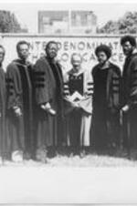 A group of students and faculty pose in front of the ITC sign on campus for convocation. Left to right: Q. R. Gordon, O. J. Haney, A. L. Dopson, J. H. Costen, H. V. Richardson, B. J. Saucer, C. W. Cone, C. J. Sargent, M. J. Jones.